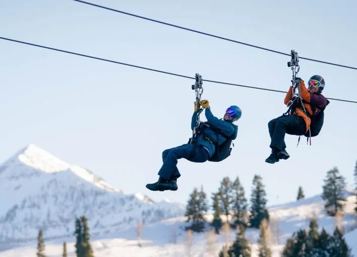 Two people ziplining